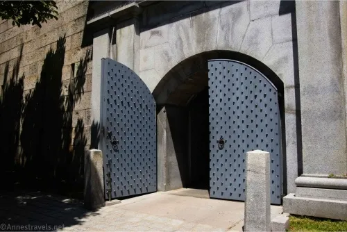 A curving entryway with one open and one closed blue door