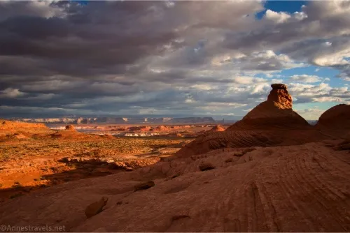 Dark skies hang over a rock formation and red-rock views