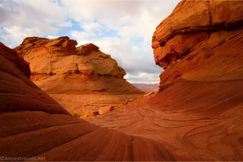 Red rocks with a filtered-light glow under white cloudy skies