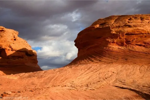 Two red buttes rise below threatening skies