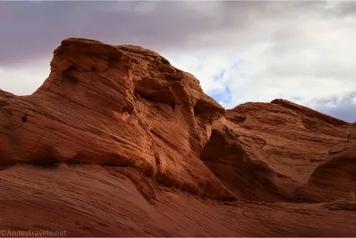 Red rock formations below cloudy skies