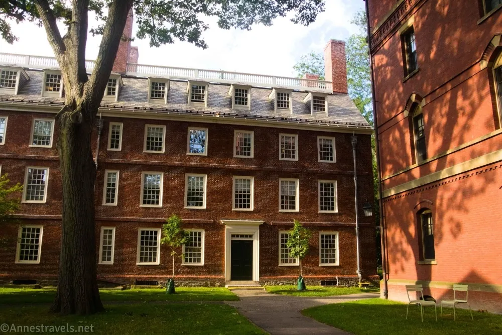 A brick building with many white windows and several chimneys