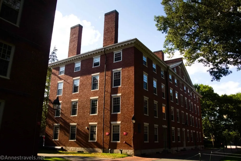 A brick building with many windows and two chimneys