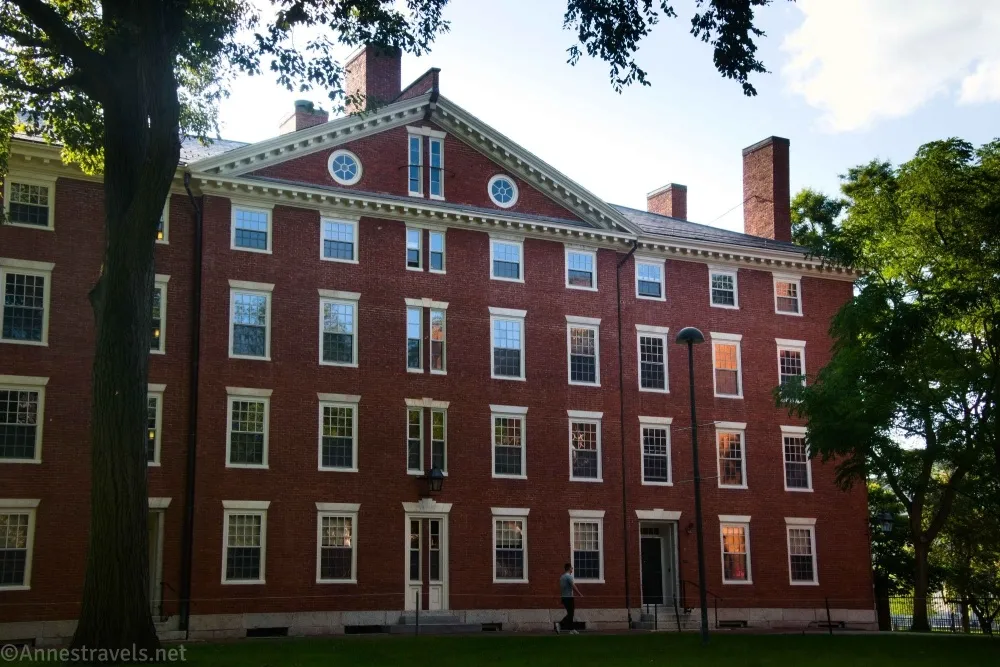 A brick building with many white-framed windows and several chimneys