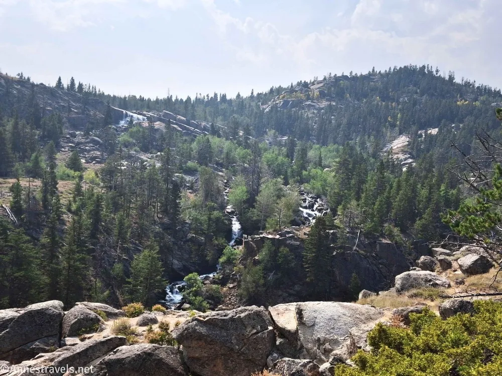 A waterfall descends a treed hillside