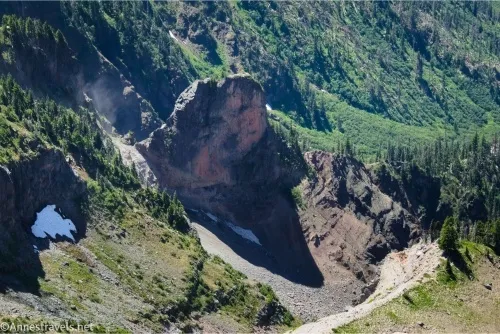 A tower of rock surrounded by green hillsides