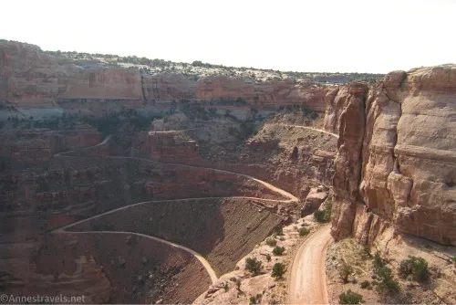 Switchbacks of a road rise up the side of a desert canyon 