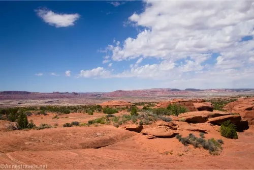 Clouds sail over a desert plain and red slickrock