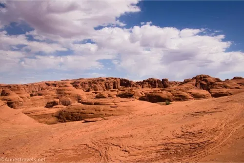 Clouds sail over red slickrock and rock formations