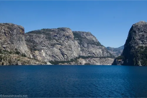 Rocky cliffs rise out of the blue waters of Hetch Hetchy Reservoir.
