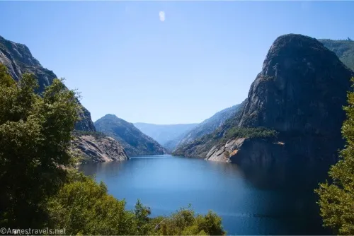 A blue lake sits quietly below rocky domes