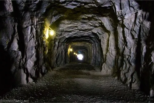 Lights illuminate the inside of an old tunnel carved out of the rock