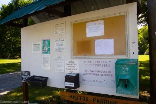 A sign kiosk with several signs and a donation box