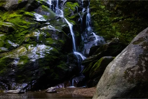 A waterfall tumbles down mossy rocks