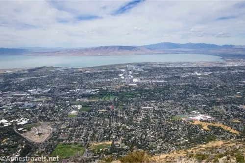 An areal view of a city with a lake and mountains beyond