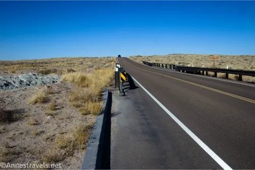 A road crosses a bridge over a desert wash