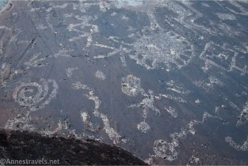 An assortment of rock art including a swirl and what might be a human 