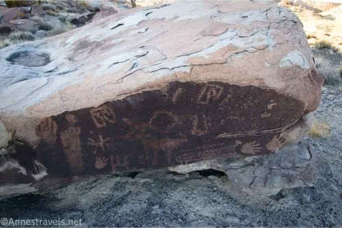 A boulder with rock art on it, including several feet 