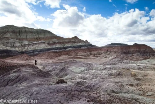Colorful striped badlands below clouds in the sky
