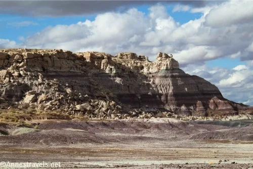 Badland butte with rocks and badlands and clouds beyond