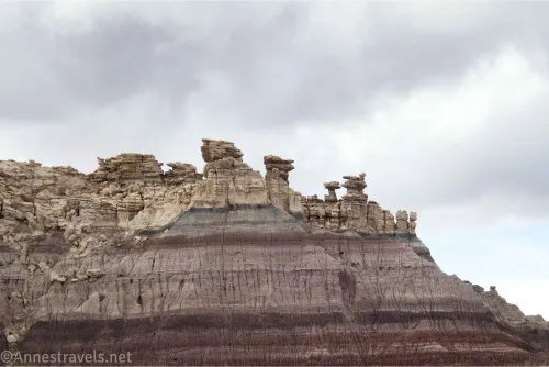 Rock formations on top of a colorful badland wall