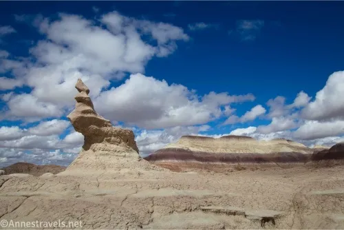 A rock formation on a badland below clouds in the sky
