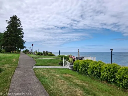 A sidewalk and lawns beside a lake 