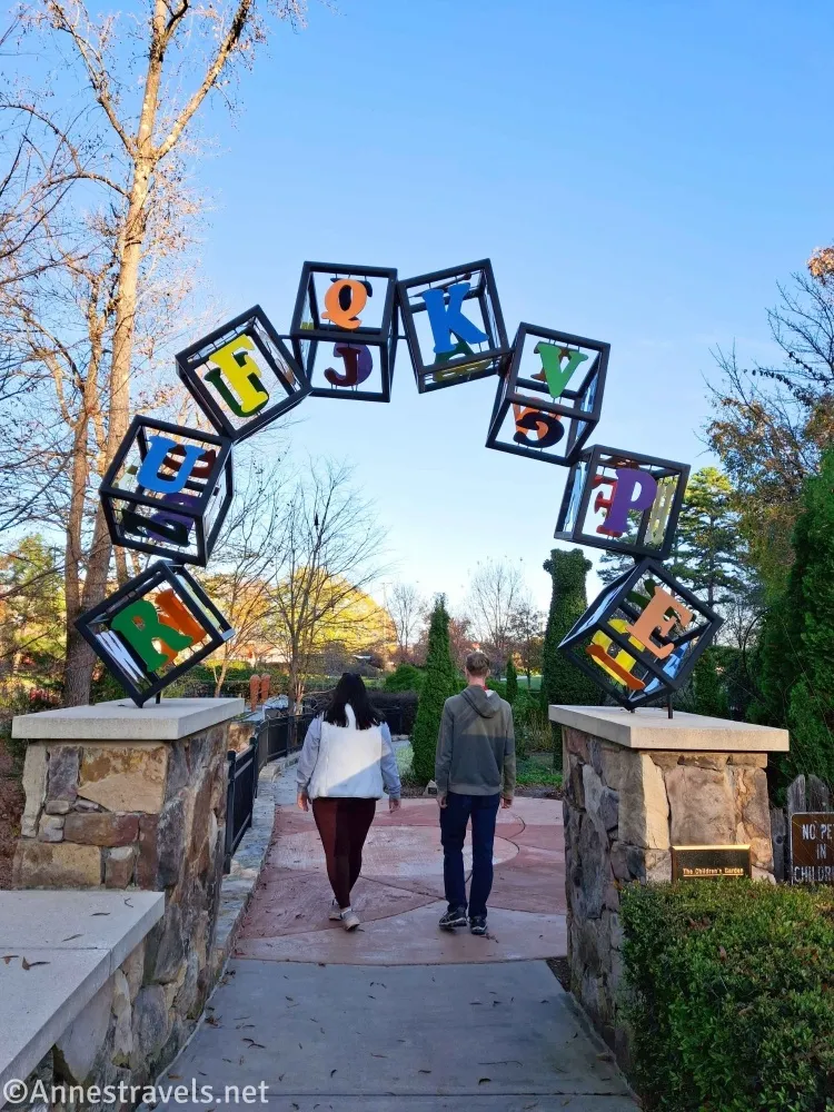 Two walkers beneath an archway made up of boxes with letters on them