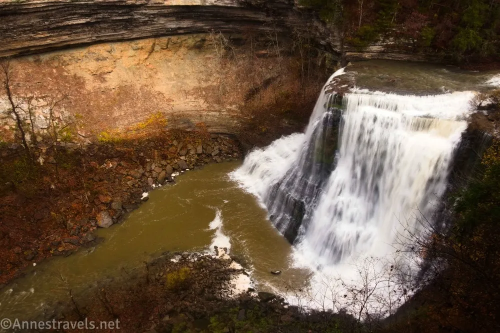 A large waterfall tumbles into a canyon with a sheer cliff wall