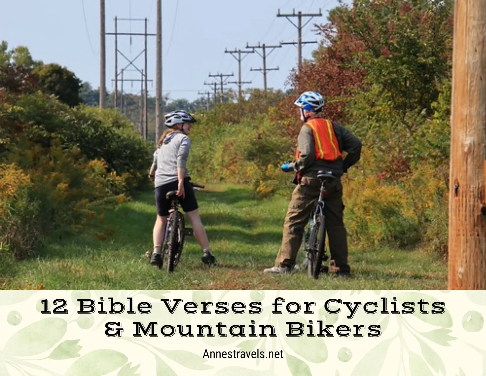 Two bicyclists on a grassy path beneath powerlines and surrounded by fall colors 