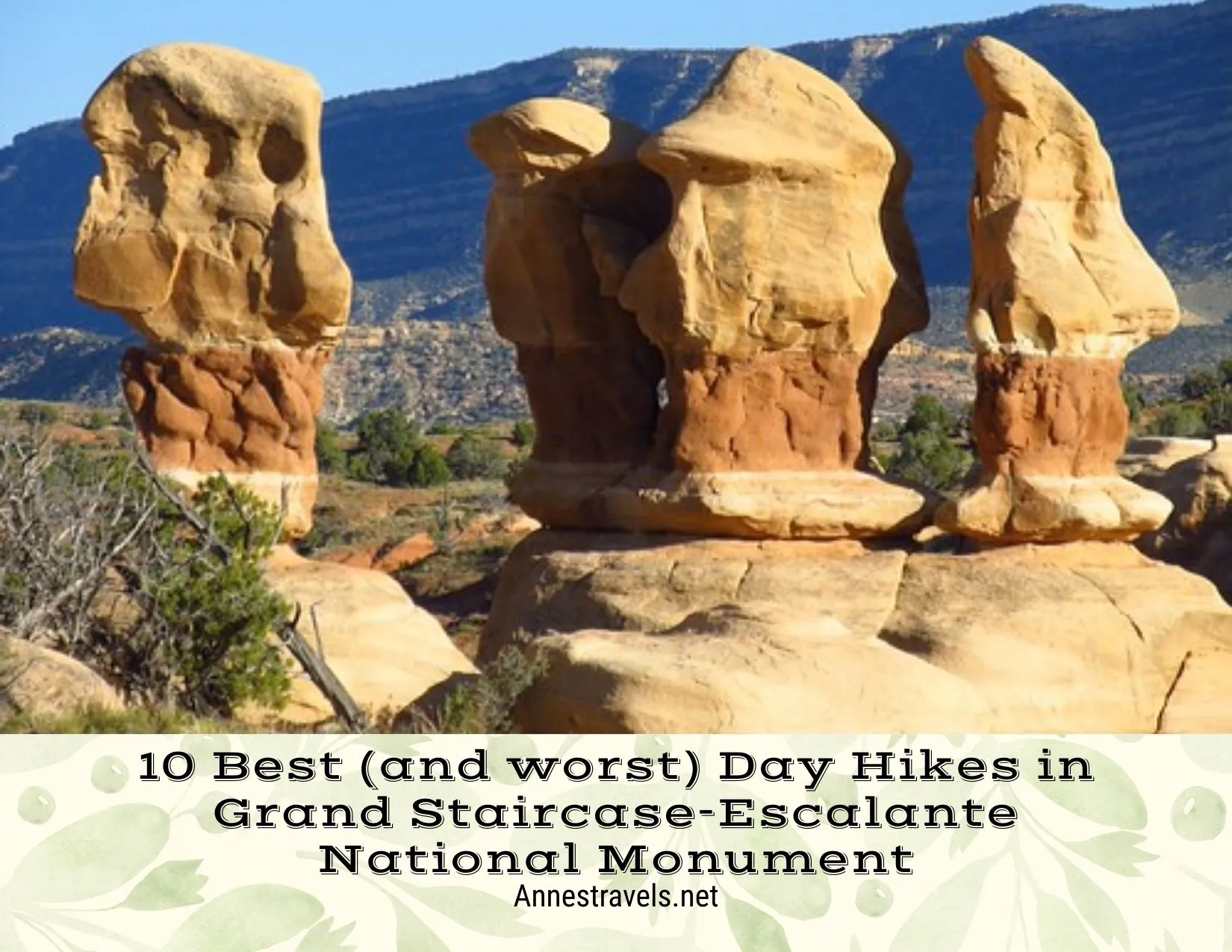 Orange and yellow rock formations in front of a shadowy hill in the desert 