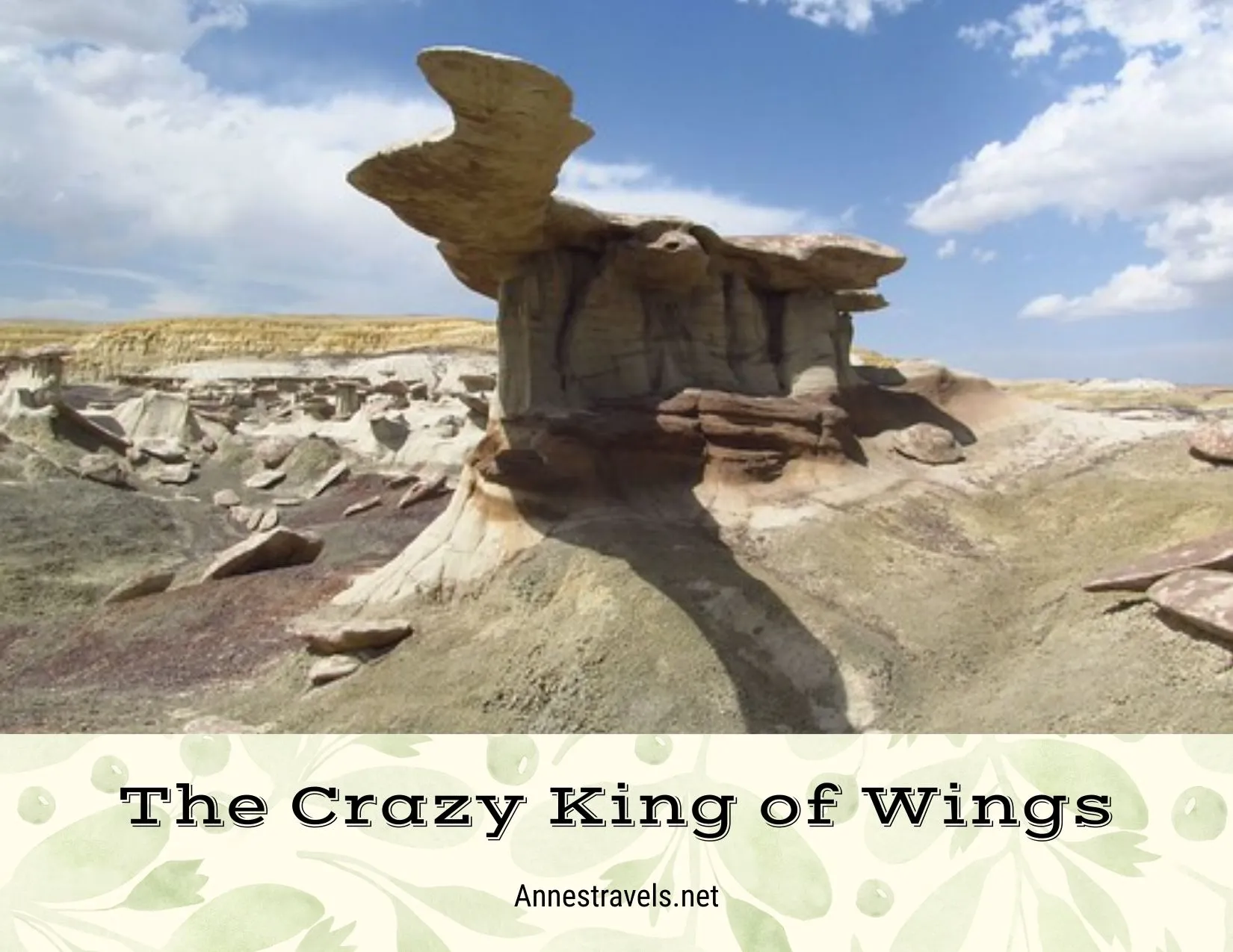 A strange rock formation in a desert of badlands below a sky with clouds