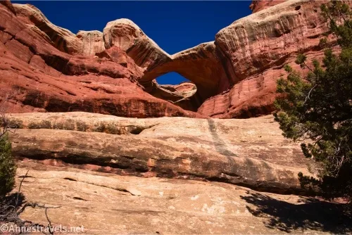 Red and white rock with an arch near the top of the cliff
