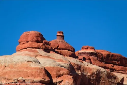 Red rock formations tower into the sky above white and red cliffs