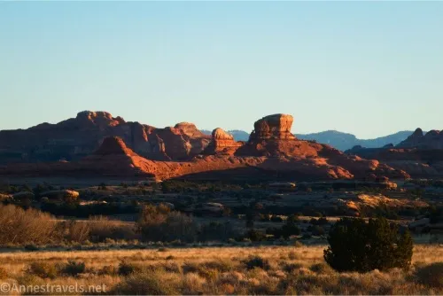 Rock formations across a grassy, brushy meadow