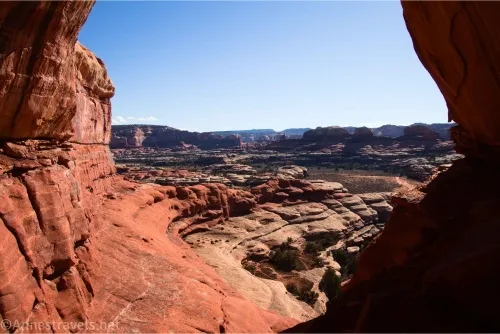 Red cliff walls framing rock formations in a desert canyon