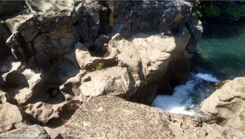 Potholes in a canyon with a pool of water on the right 