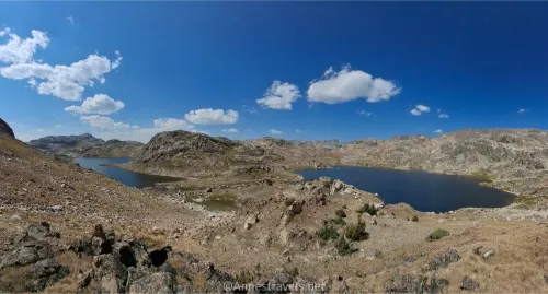Two lakes sit on a rocky tundra plain in the mountains 