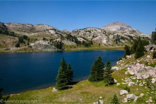 Becker Lake sits between meadows and rounded mountains 