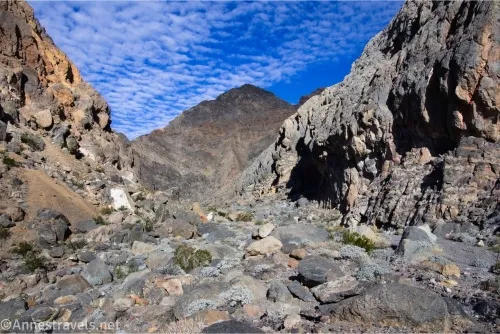 Rocks in the wash of a desert canyon with blue skies and clouds 