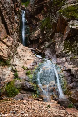 Two-tiered waterfall tumbling down rock layers 