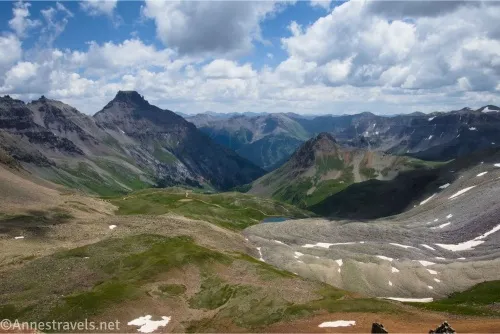 Clouds sail over mountains an a grassy valley 