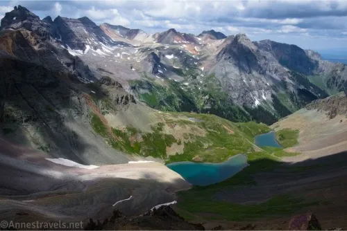 Rugged and slightly snowy mountains above two blue lakes