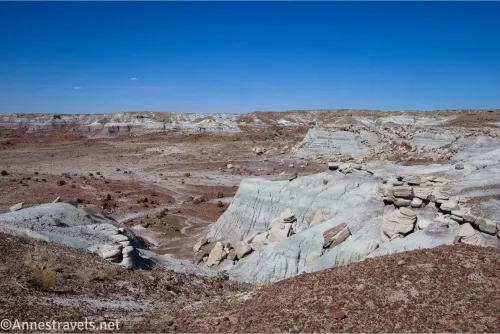 Badlands topped with rocks above a desert plain and more badlands 