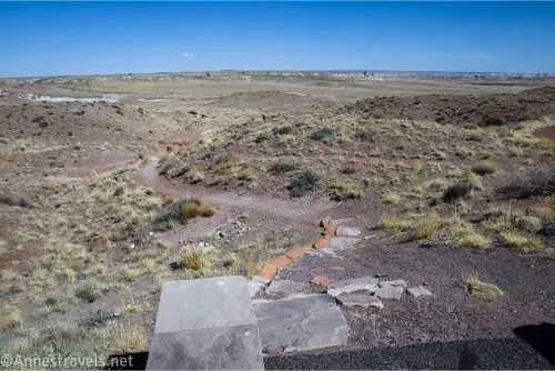 A path descends from a rock slab into the desert 