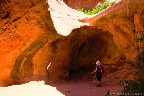 A hiker stands below a dryfall