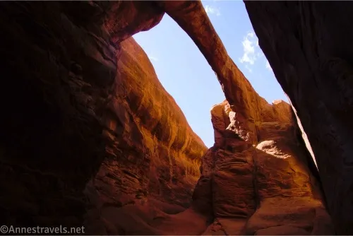 A massive arch between two sandstone fins with blue sky beyond