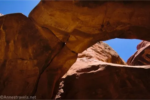 An arch in a canyon with blue sky beyond