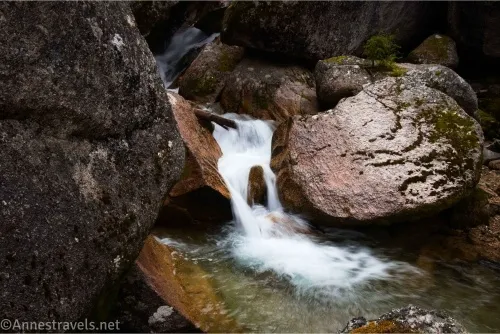 A stream tumbles in a waterfall between large rocks