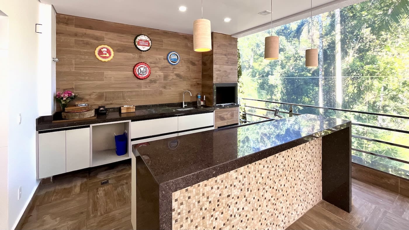 Espaço gourmet com ilha central e revestimento em madeira